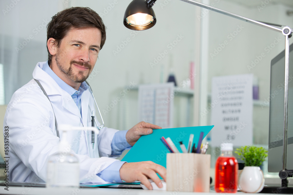 male doctor at his desk using a computer male doctor at his desk using a computer