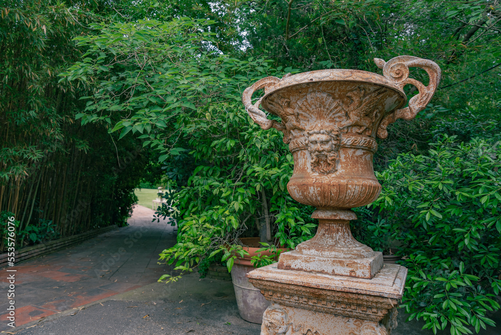 Old decorative vase in the garden next to bamboo Old decorative vase in the garden next to bamboo