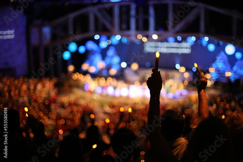 Christmas Eve service in church with candles being held up in the air