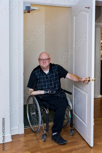 Man with double limb amputations entering home elevator; St. Albert, Alberta, Canada