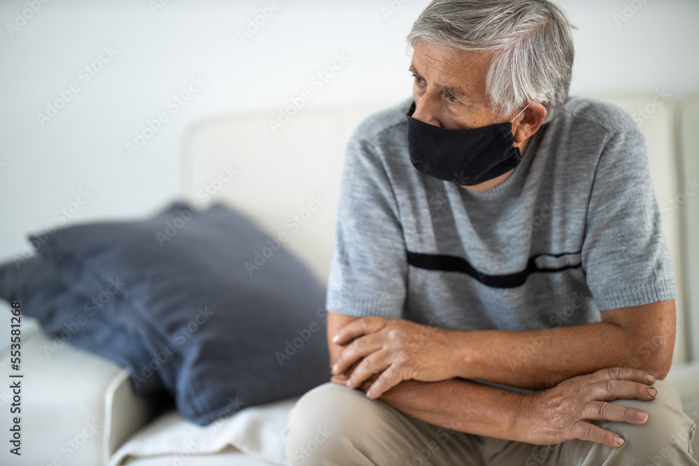 Senior man wearing a facemask during coronavirus and flu outbreak. Virus and illness protection, home quarantine. COVID-19 concept Senior man wearing a facemask during coronavirus and flu outbreak. Virus and illness protection, home quarantine. COVID-19 concept