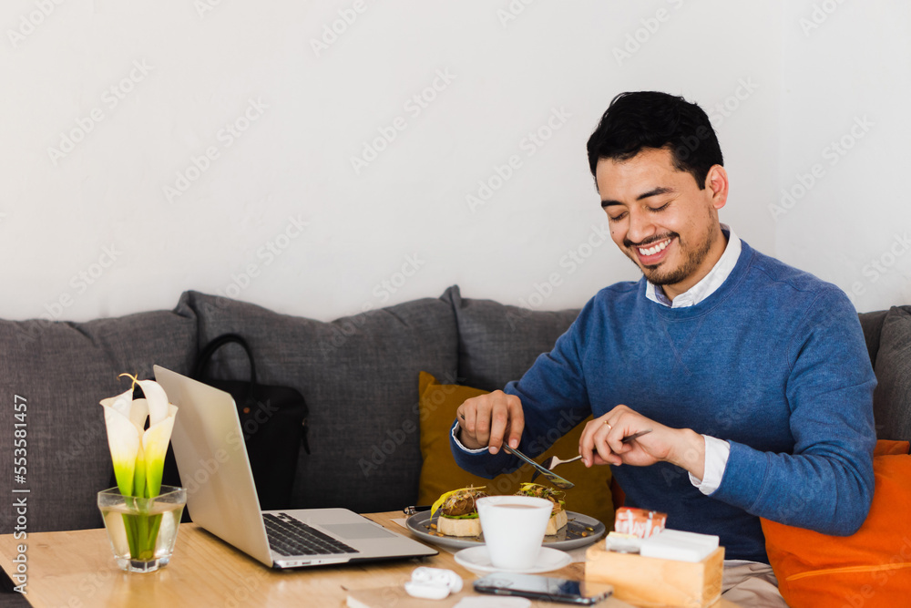 A male person smiling and enjoying sitting in a cafeteria having breakfast. Lifestyle. A male person smiling and enjoying sitting in a cafeteria having breakfast. Lifestyle.