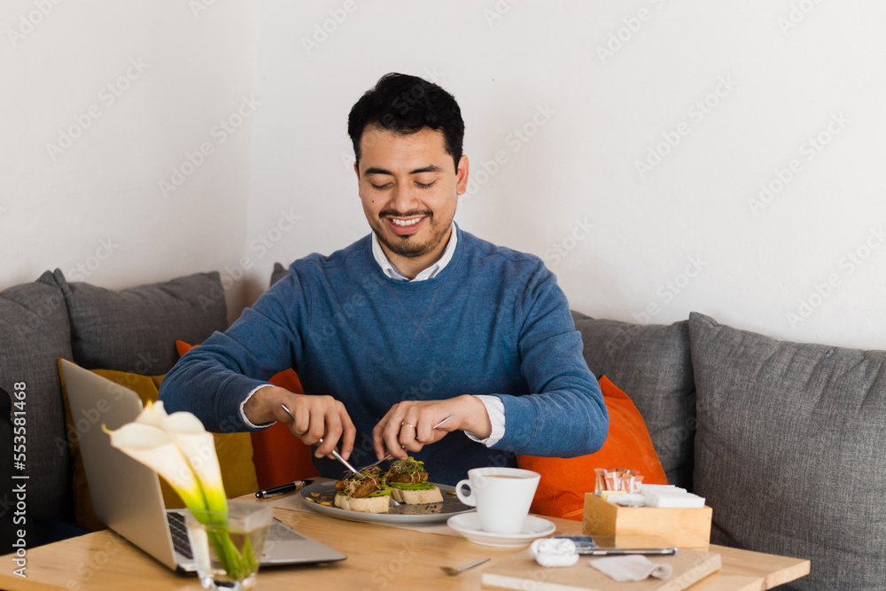 Young Caucasian man sitting in a restaurant having breakfast. Food. Young Caucasian man sitting in a restaurant having breakfast. Food.
