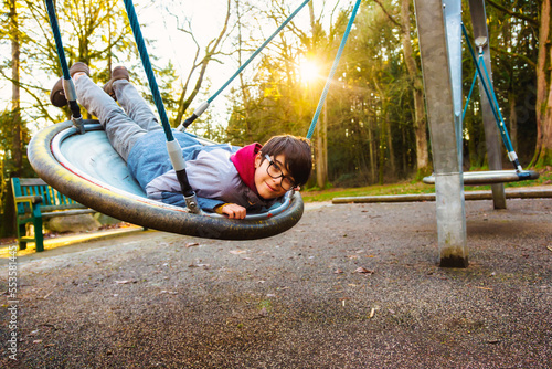 A boy plays on a saucer at a playground in autumn; Langley, British Columbia, Canada photo