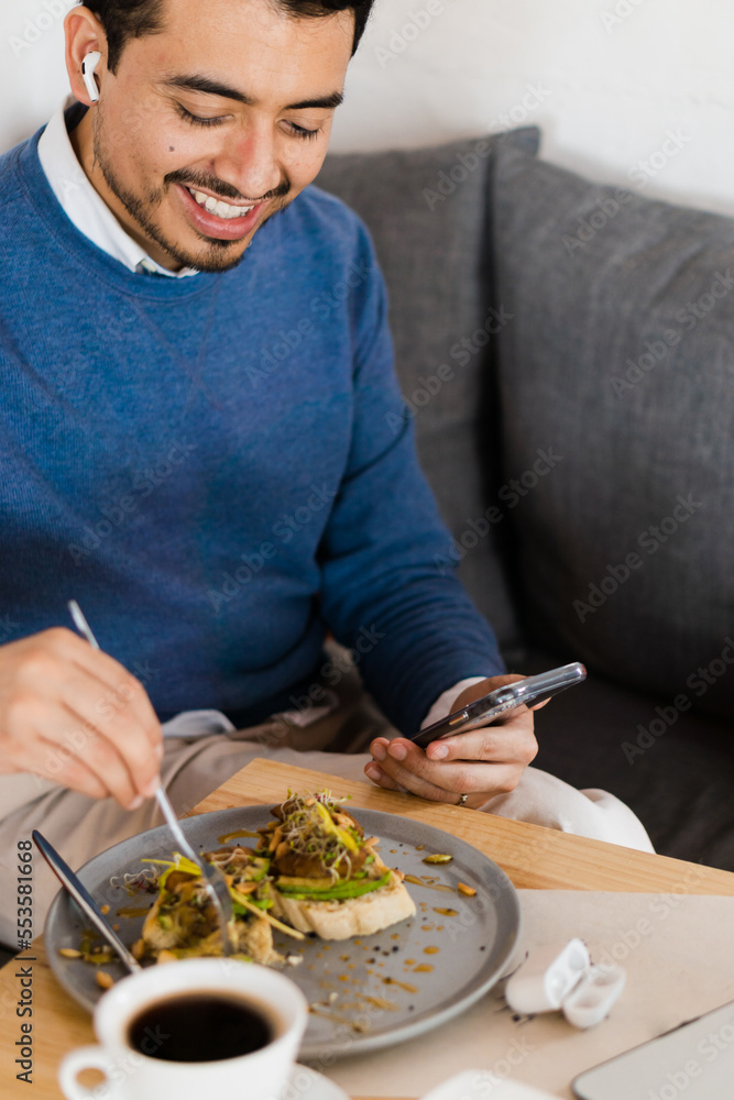 Businessman smiling, eating and talking on the phone at home. Lifestyle. Businessman smiling, eating and talking on the phone at home. Lifestyle.