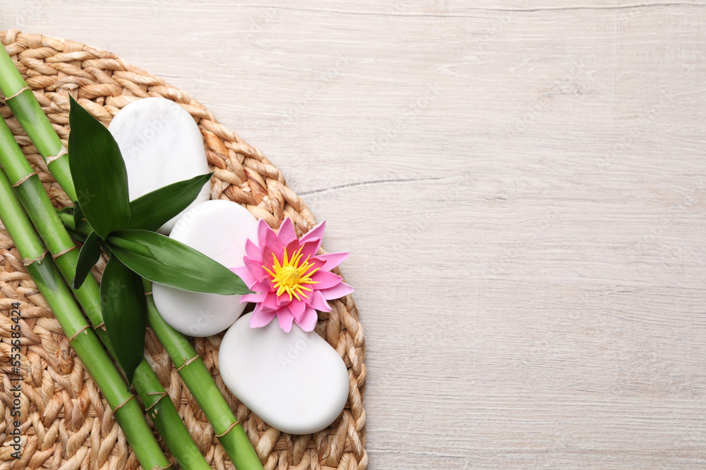 Bamboo, spa stones and flower on light wooden table, flat lay. Space for text Bamboo, spa stones and flower on light wooden table, flat lay. Space for text