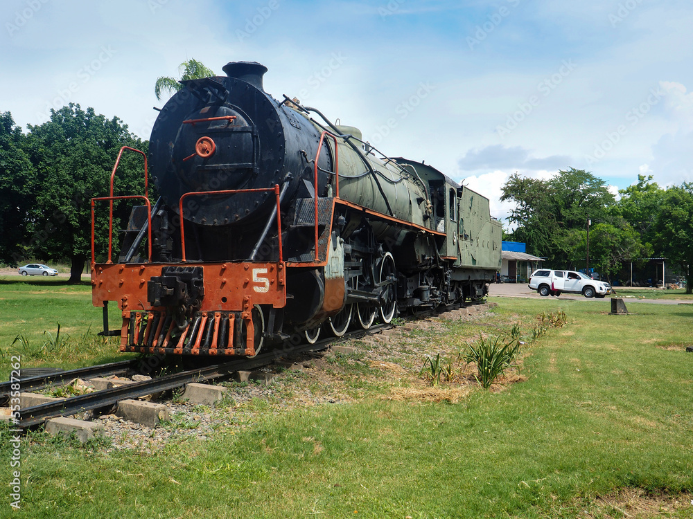 VICTORIA FALLS, ZIMBABWE, AFRICA - December 20, 2017: A static display of a former South African 16DA steam engine that sits in a small park VICTORIA FALLS, ZIMBABWE, AFRICA - December 20, 2017: A static display of a former South African 16DA steam engine that sits in a small park
