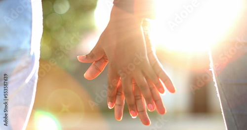 Black couple holding hands outside during golden hour time sunset