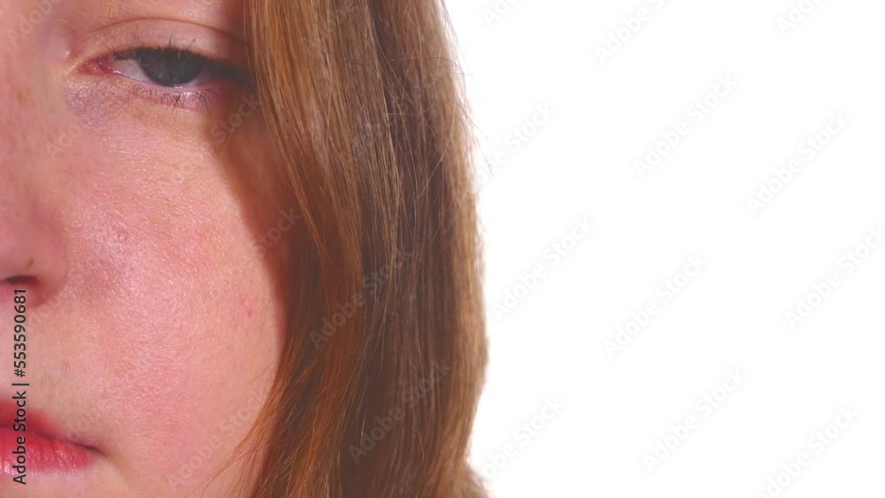 pensive young woman stares at camera blinking - half face pensive young woman stares at camera blinking - half face