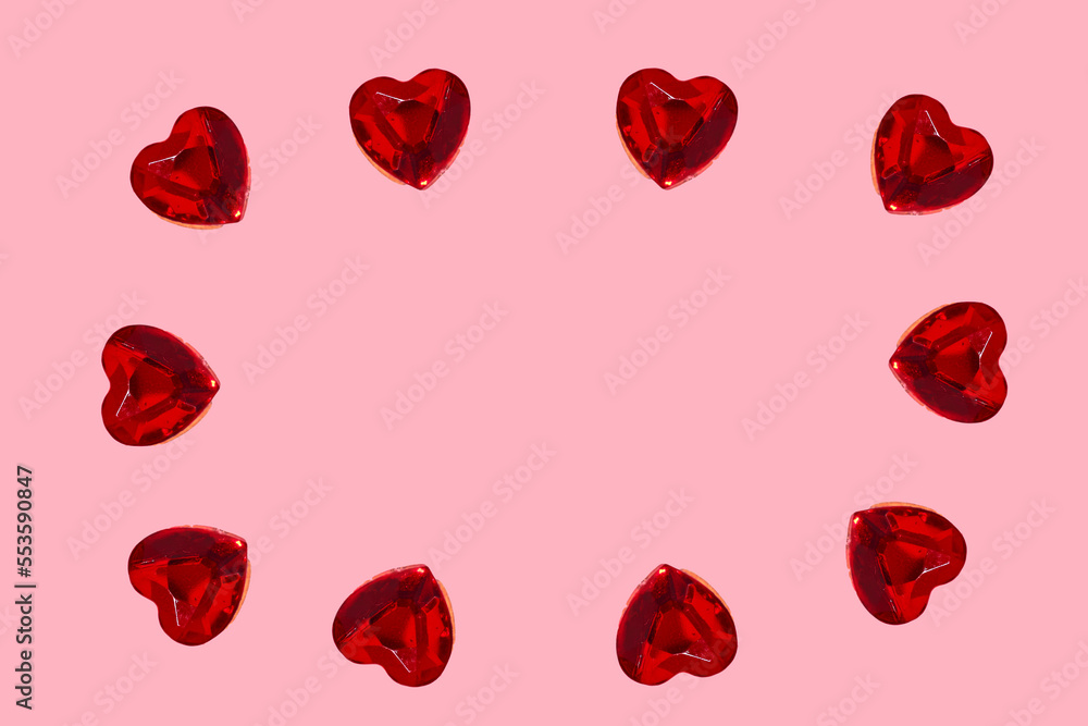 Love in valentine's day concept. Design with copy space. Heart shaped rubies over pink background forming circle around blank space for text Love in valentine's day concept. Design with copy space. Heart shaped rubies over pink background forming circle around blank space for text