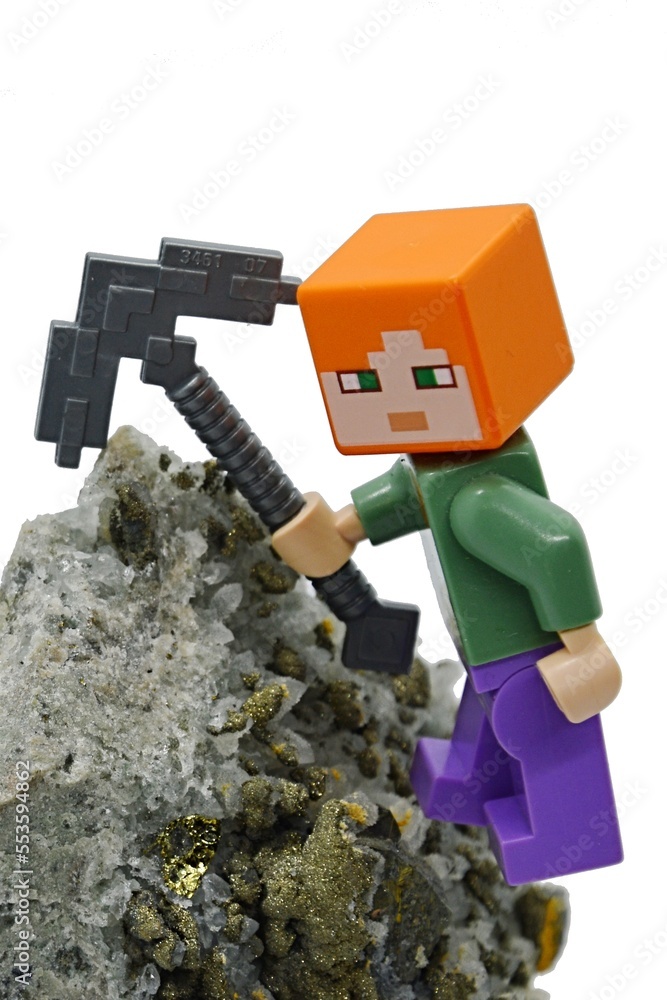 Naklejka premium LEGO Minecraft figure of Alex with iron pickaxe on Chalcopyrite mineral rock, white background.