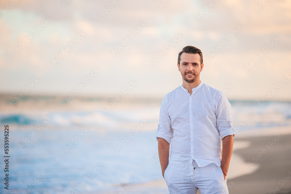 Young man in white on the beach having fun Young man in white on the beach having fun