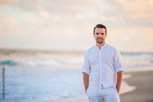 Young man in white on the beach having fun