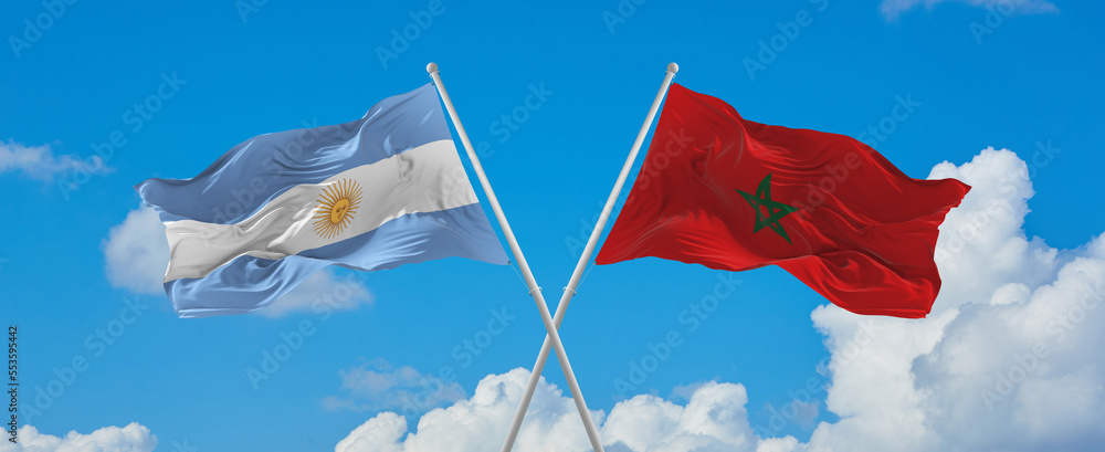 crossed national flags of Argentine and Morocco flag waving in wind at ...