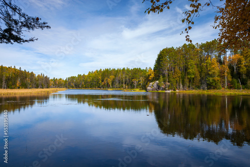 Fototapeta Naklejka Na Ścianę i Meble -  Calm lake in northern Minnesota with trees and rocks on a bright autum day