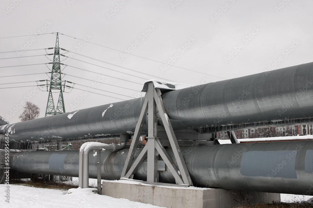 pipeline and power line in the city in winter against the gray sky. pipeline and power line in the city in winter against the gray sky.