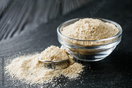 asafoetida aromatic powder on a black stone background photo