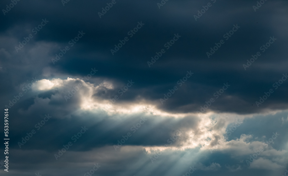 Beautiful nature background. Rays of sunlight through the clouds.