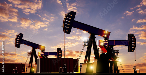 Oil platforms in evening. Panorama field of hydrocarbons. Sea containers in oil fields. Petroleum industry. Oil and gas sector. Drilling rigs glow against backdrop of sunset. 3d image. photo