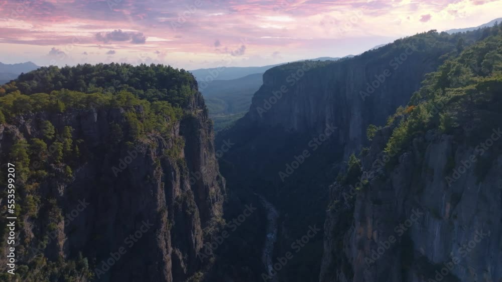 Flight over high rocks in mountainous area. Sunset sky. The tops of the trees. Aerial drone video footage Flight over high rocks in mountainous area. Sunset sky. The tops of the trees. Aerial drone video footage
