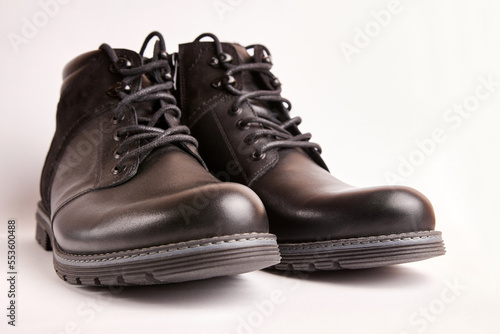 Black leather men's boots on a white background. Warm shoes for winter. © Vasyl