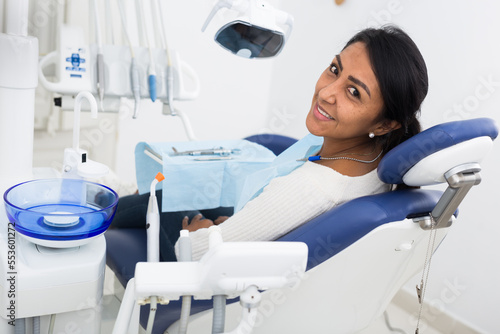 Portrait of smiling latin american woman after dental procedure in dentist office