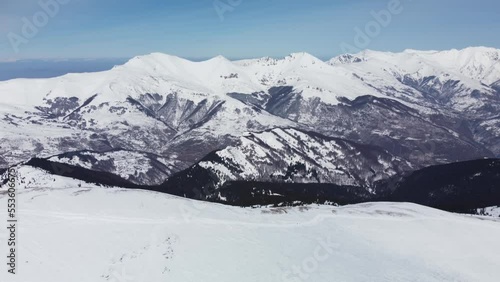 Aerial view of mountains in snow. Snowcat tracks visible. photo