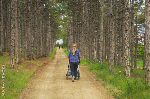 a woman with a pram walks