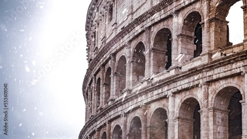 Rome christmas lights blurred while snow falling in slow motion. Grey clouds in background. Coliseum or Flavian Amphitheatre (Amphitheatrum Flavium or Colosseo), Rome, Italy. photo