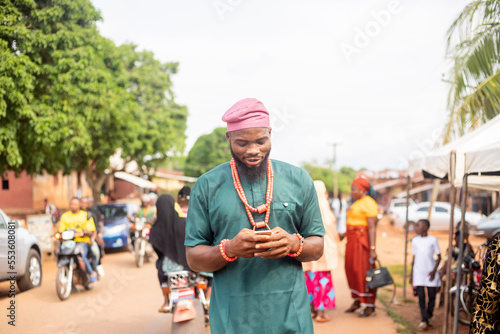 Handsome African man excited looking at mobile at hand
