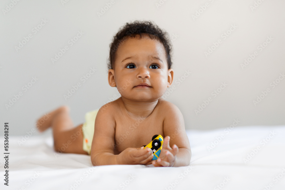 Portrait Of Cute Little Black Baby Lying In Bed On His Tummy Portrait Of Cute Little Black Baby Lying In Bed On His Tummy