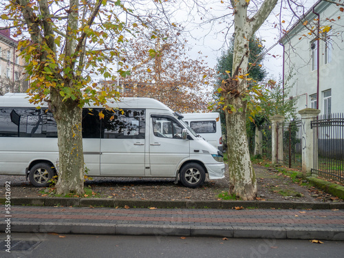 Minibuses at the old house. Yard in Batumi. Parked vehicles.