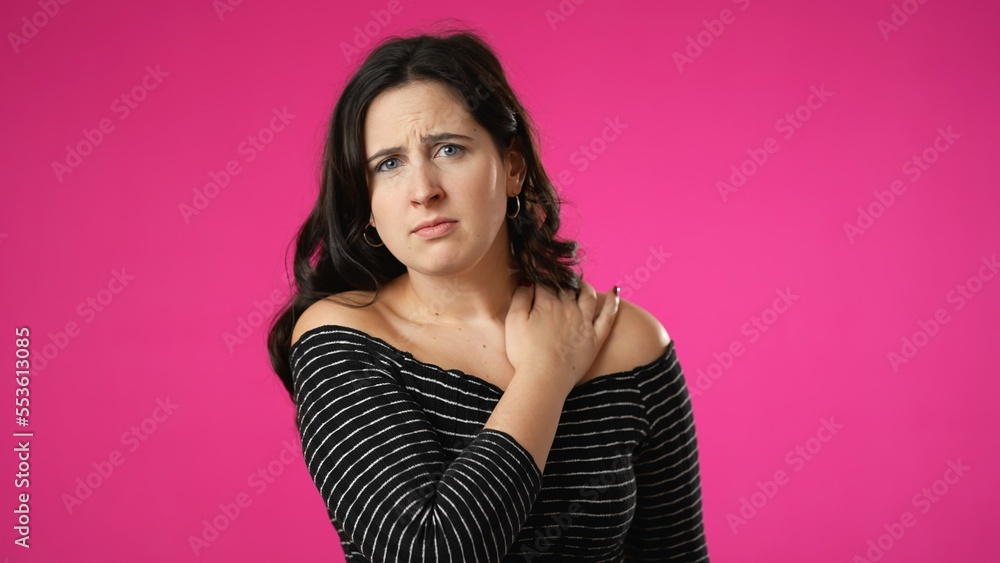 Portrait of young hipster woman 20s with sore neck shoulder pain problem isolated on pink background in studio Portrait of young hipster woman 20s with sore neck shoulder pain problem isolated on pink background in studio