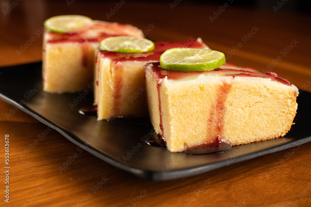 three pieces of lemon brownie with blackberry jam marmalade cover on a square black plate dish, dark food photo three pieces of lemon brownie with blackberry jam marmalade cover on a square black plate dish, dark food photo