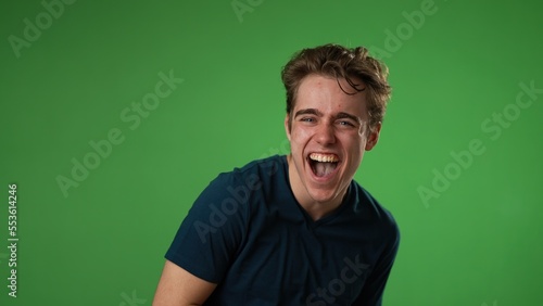 portrait of laughing smiling happy young hipster man 20s isolated on green screen chroma key background with copy space in studio