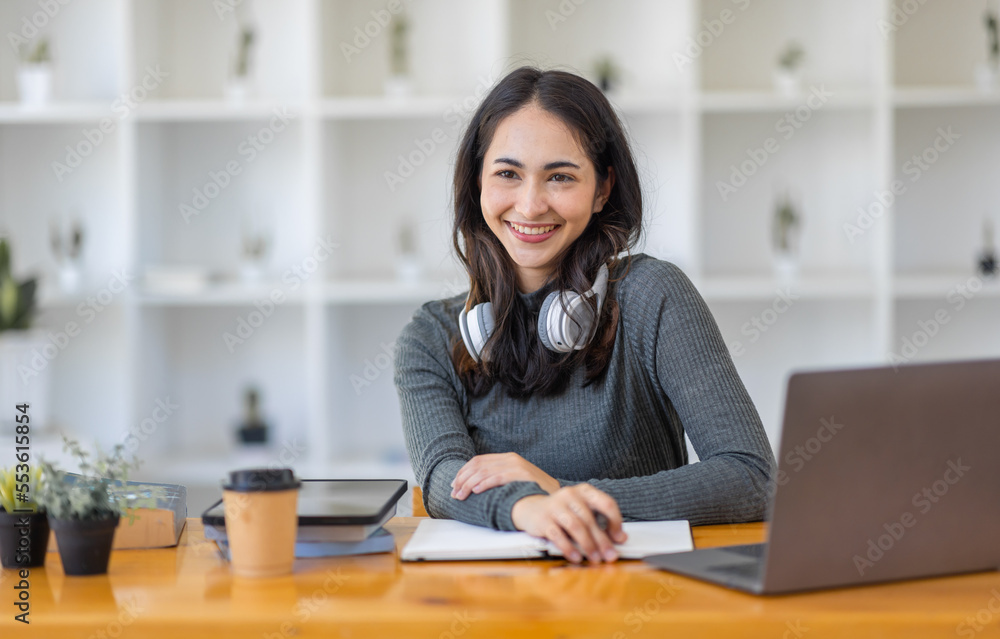 Young adult happy smiling Hispanic Asian student wearing headphones talking on online chat meeting using laptop in university campus or at virtual office. College female student learning remotely.
Young adult happy smiling Hispanic Asian student wearing headphones talking on online chat meeting using laptop in university campus or at virtual office. College female student learning remotely.