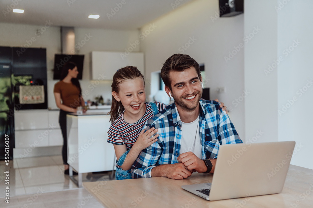 Father and daughter in modern house talking together on laptop with their family during holidays. The life of a modern family Father and daughter in modern house talking together on laptop with their family during holidays. The life of a modern family