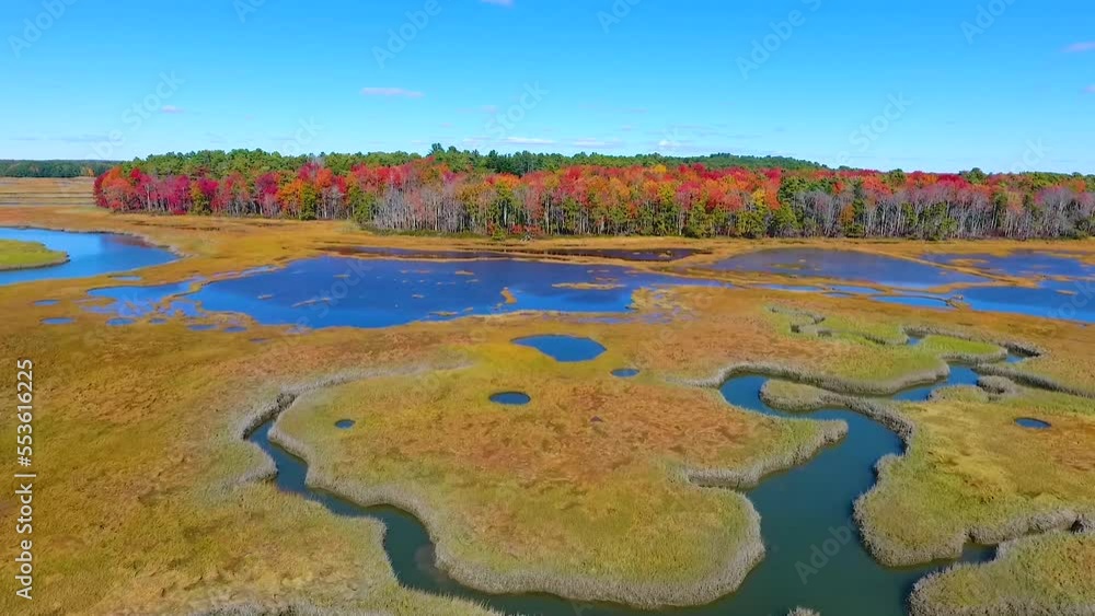 Aerial over Maine marshes with patches of shallow water towards fall forests Aerial over Maine marshes with patches of shallow water towards fall forests