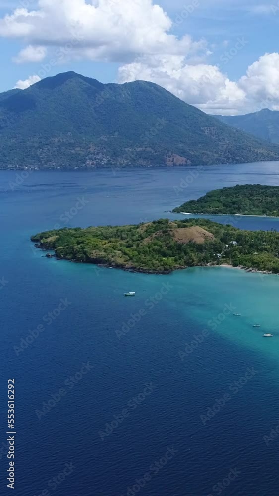 Vertical video of Aerial shot of a tropical volcanic island with turquoise water Vertical video of Aerial shot of a tropical volcanic island with turquoise water