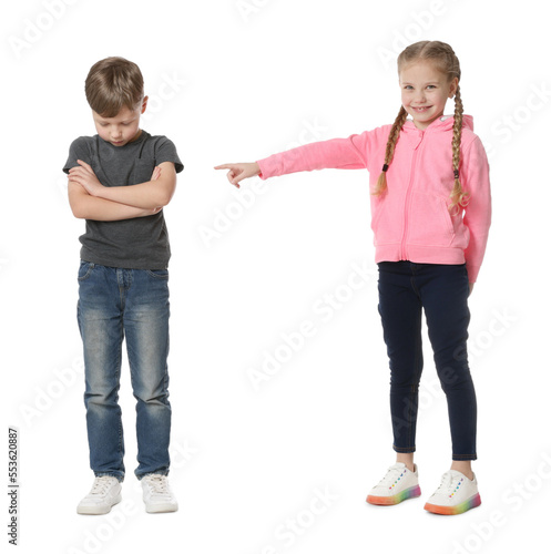 Girl laughing and pointing at upset boy on white background. Children's bullying