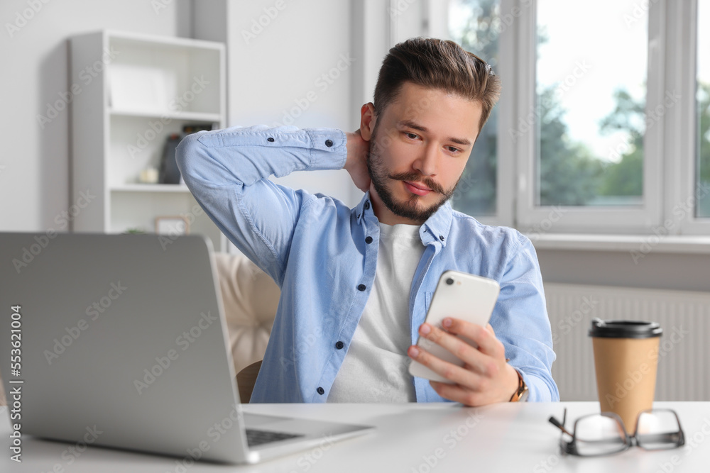 Man using smartphone while working in office Man using smartphone while working in office