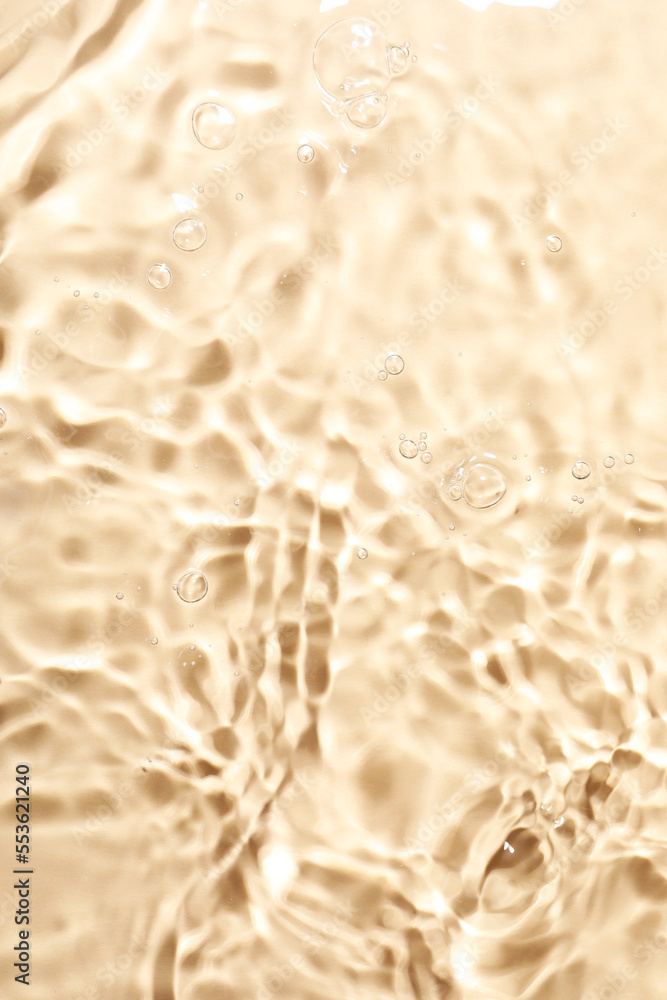 Closeup view of water with rippled surface on beige background Closeup view of water with rippled surface on beige background