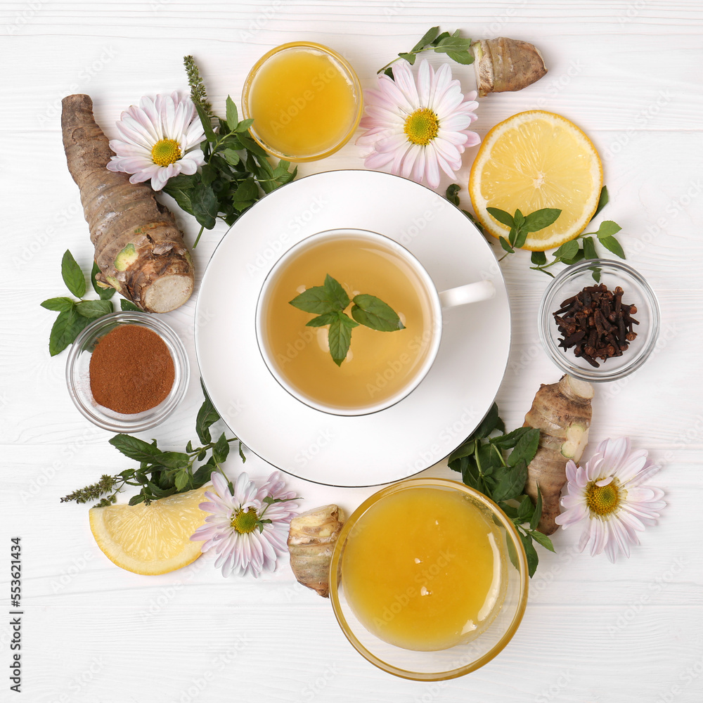 Flat lay composition with cup of delicious tea, honey and ginger on white wooden table Flat lay composition with cup of delicious tea, honey and ginger on white wooden table