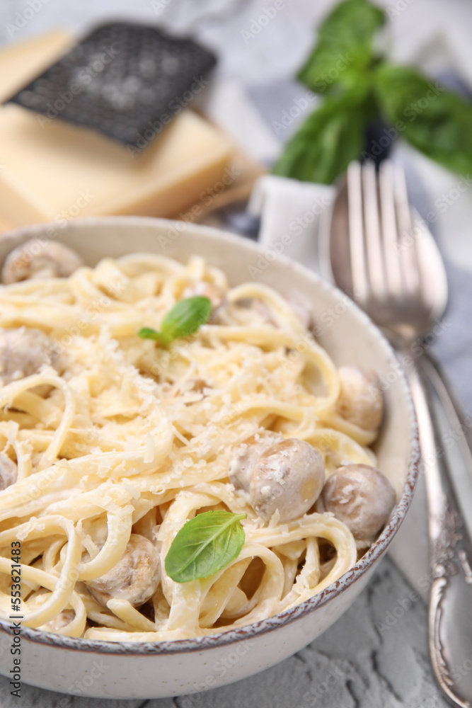 Delicious pasta with mushrooms and cheese in bowl on table, closeup