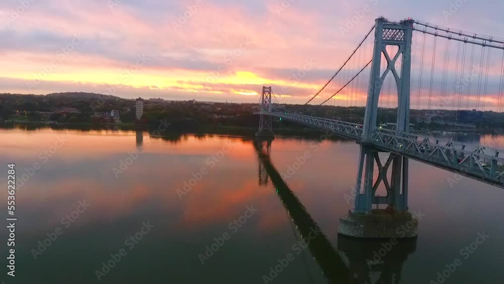 Aerial along Hudson River bridge with stunning pink and gold sunrise light Aerial along Hudson River bridge with stunning pink and gold sunrise light
