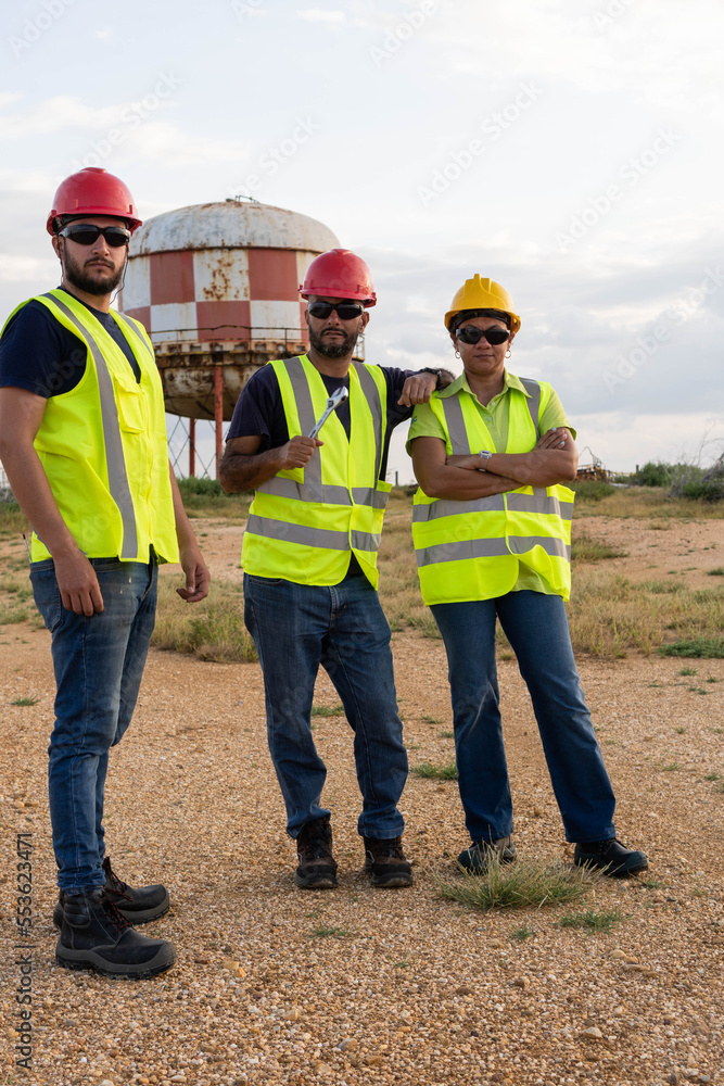 Latino industrial workers standing in the open air Latino industrial workers standing in the open air