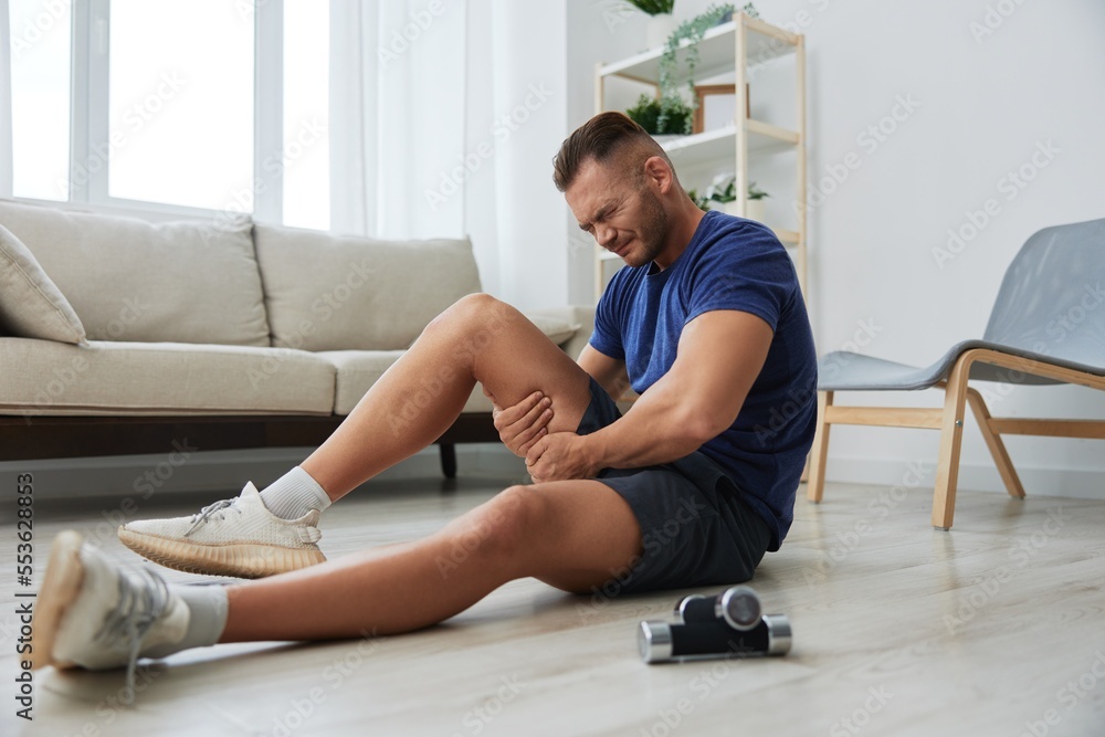 Man athlete pain and injury back arm and leg at home, sports injury bodybuilder, concept health and beauty Man athlete pain and injury back arm and leg at home, sports injury bodybuilder, concept health and beauty