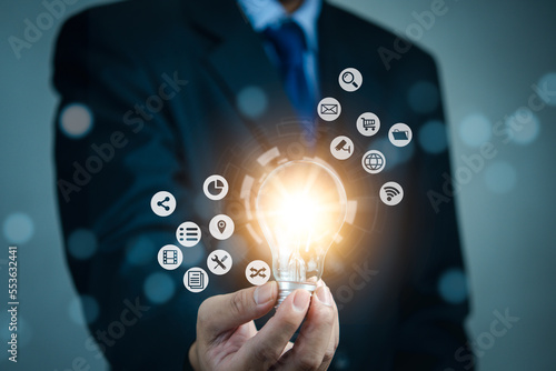 Businessman holding light bulb and new ideas. Creative and inspiration.business with innovative technology network connection. Innovation finance and economic growth concept.