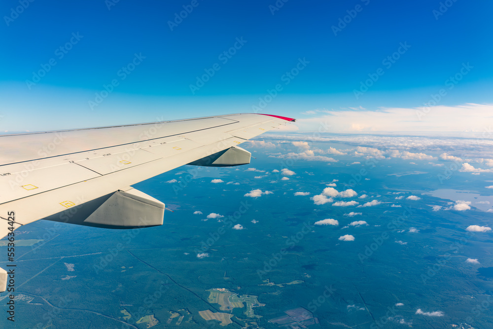 View from the airplane window at a beautiful cloudy sky and the airplane wing View from the airplane window at a beautiful cloudy sky and the airplane wing