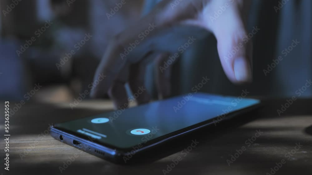 woman hand picking up smart phone mobile showing incoming call on the screen,indoor night time,smartphone ringing woman hand picking up smart phone mobile showing incoming call on the screen,indoor night time,smartphone ringing